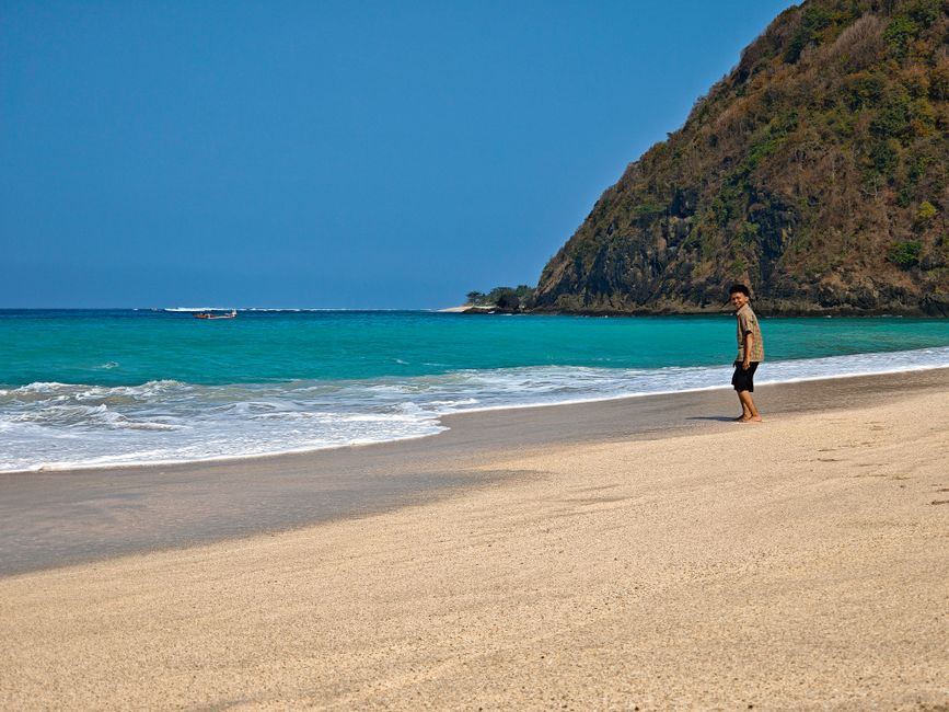 Walking a sand beach beside clear water, West Nusa Tenggara